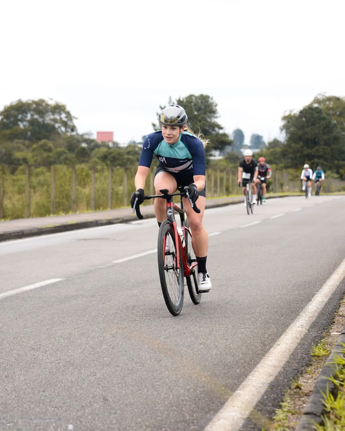 Ciclista de ruta pedaleando en carretera (foto de ejemplo)